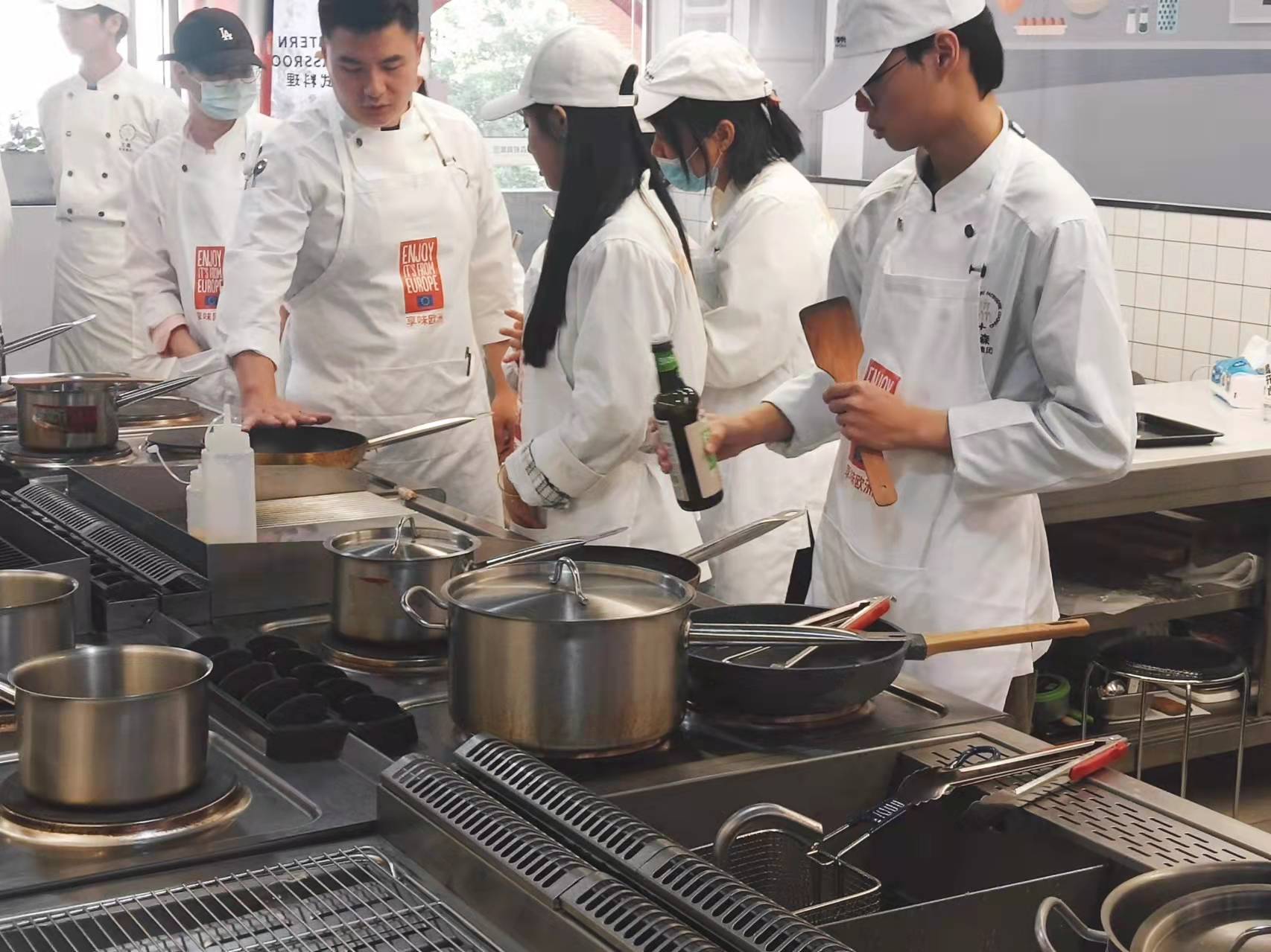 Students cooking together with teacher 