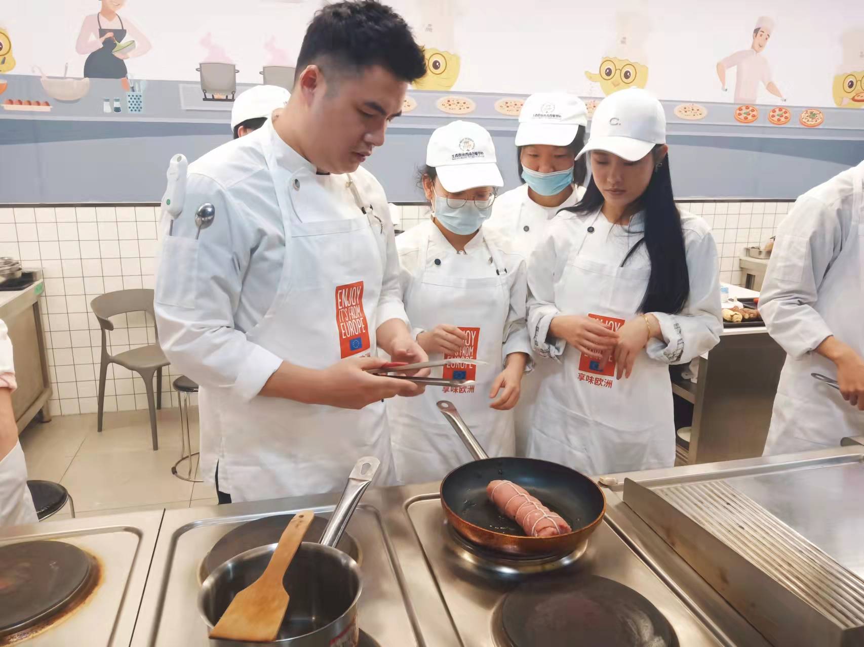 Cook showing students how to prepare a dish