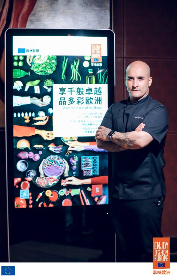 Chef in front of event banner 